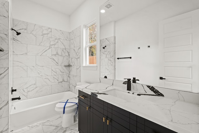 full bathroom featuring vanity, tile floors, toilet, and tiled shower / bath