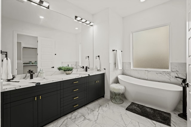 bathroom with tile walls, dual sinks, vanity with extensive cabinet space, and tile flooring