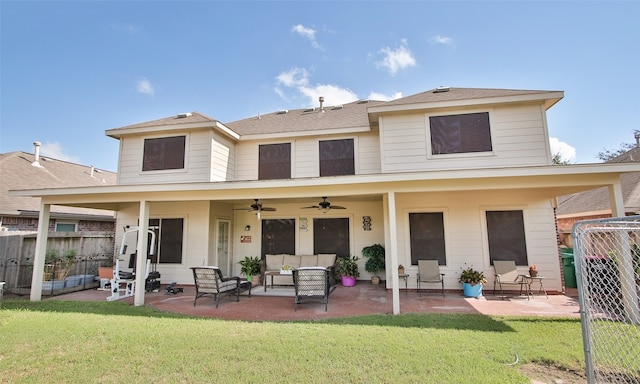 back of property featuring outdoor lounge area, ceiling fan, a patio area, and a lawn