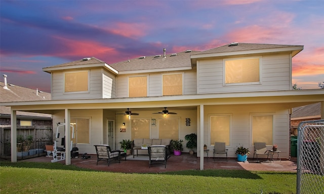 back house at dusk with a patio area, an outdoor living space, and ceiling fan