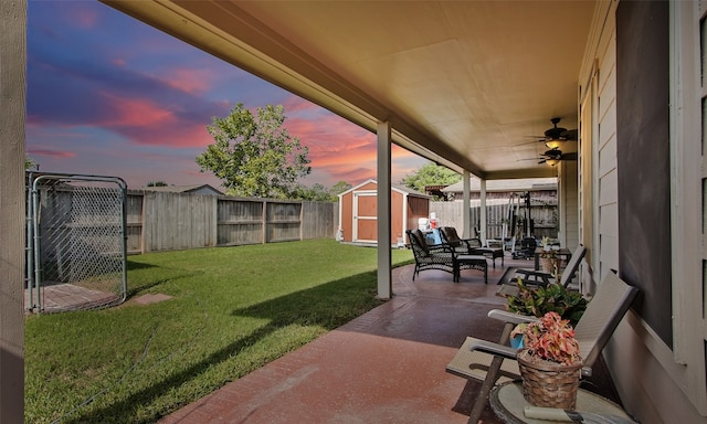 patio terrace at dusk with a lawn and a shed