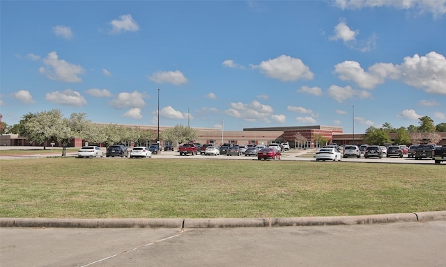 view of parking / parking lot featuring a yard