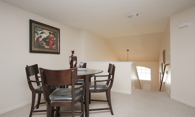 dining space with carpet and lofted ceiling