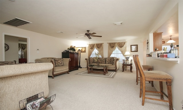 carpeted living room with ceiling fan