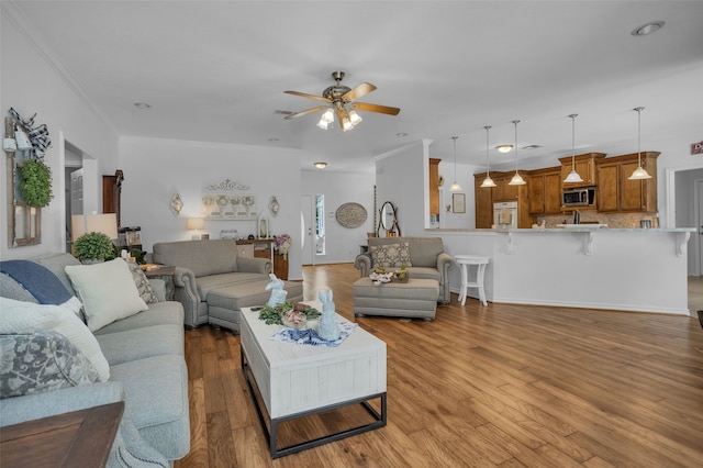 living room featuring ornamental molding, ceiling fan, and light hardwood / wood-style flooring