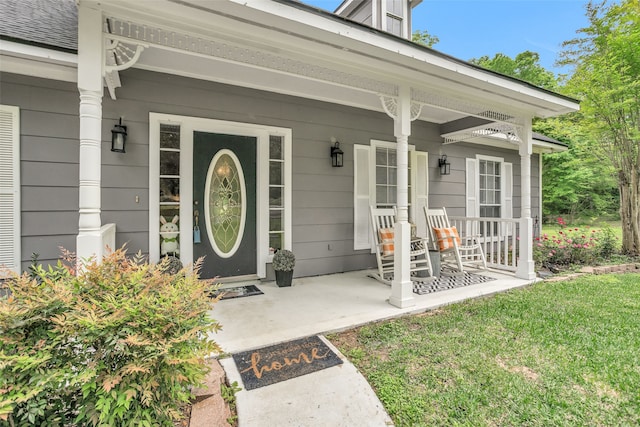 property entrance with a yard and covered porch