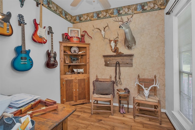 sitting room with ceiling fan and light wood-type flooring