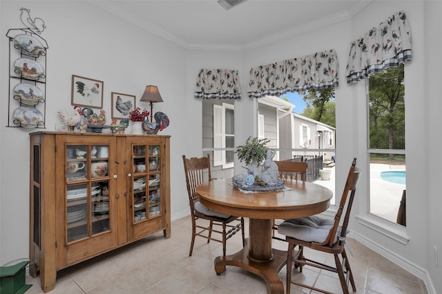 tiled dining room featuring crown molding