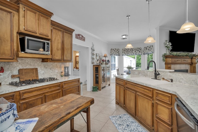 kitchen featuring appliances with stainless steel finishes, tasteful backsplash, light tile floors, pendant lighting, and sink