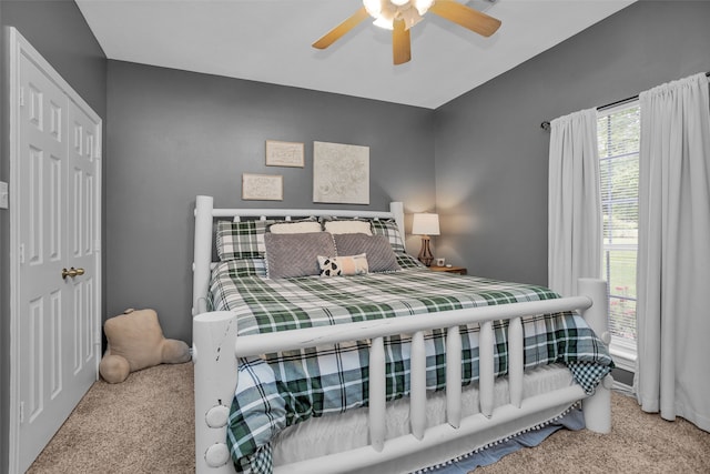 bedroom featuring ceiling fan, light colored carpet, and a closet