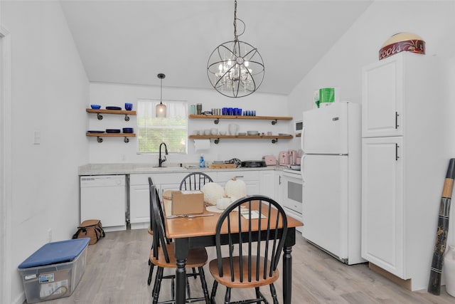 dining space featuring lofted ceiling, a chandelier, light hardwood / wood-style floors, and sink