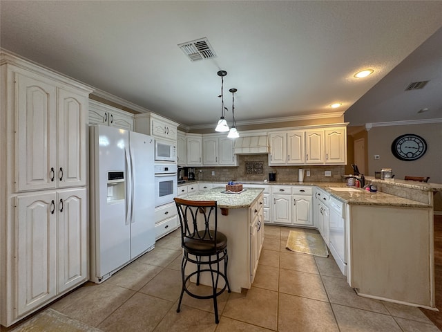 kitchen featuring a center island, white appliances, backsplash, decorative light fixtures, and light stone countertops