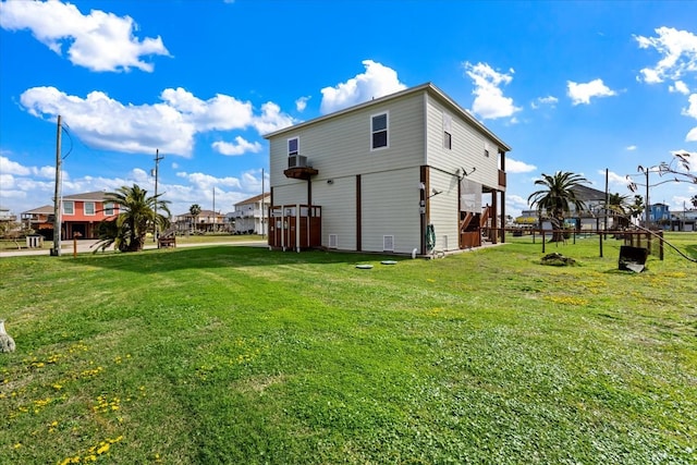 rear view of property featuring a wooden deck and a lawn