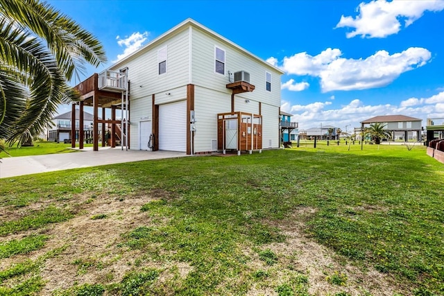 back of property featuring a lawn and a garage