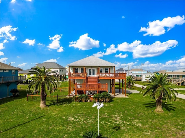 back of property with a lawn, a wooden deck, and a patio area