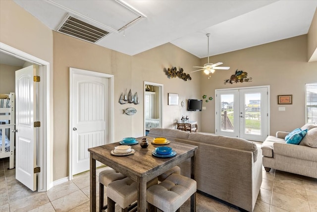 tiled dining room featuring ceiling fan, vaulted ceiling, and french doors