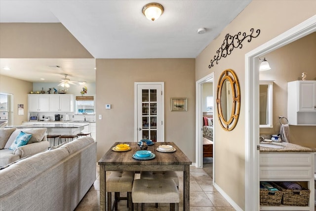 dining room with ceiling fan, sink, light tile floors, and a healthy amount of sunlight