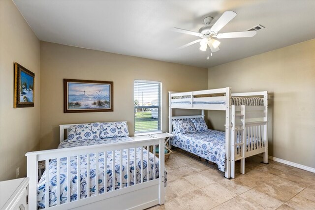 tiled bedroom featuring ceiling fan