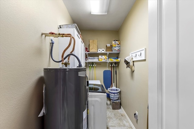 laundry room with washer / clothes dryer, gas water heater, and light tile floors