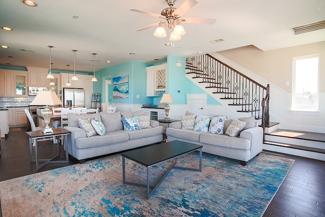 living room featuring ceiling fan and dark hardwood / wood-style flooring