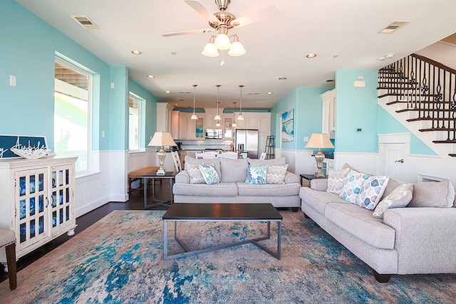 living room with ceiling fan and dark hardwood / wood-style flooring