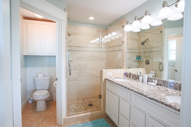 bathroom featuring double sink vanity, toilet, tile floors, and an enclosed shower