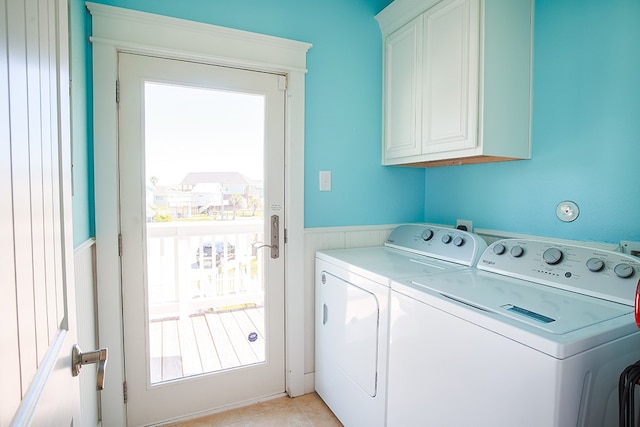 clothes washing area featuring independent washer and dryer, cabinets, and light tile floors