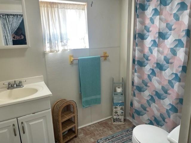 bathroom with vanity, toilet, and curtained shower