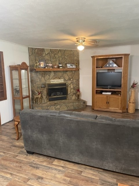 living room with a fireplace, wood-type flooring, and ceiling fan