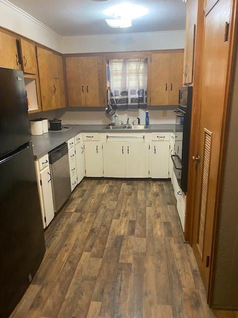 kitchen featuring appliances with stainless steel finishes, dark hardwood / wood-style flooring, crown molding, sink, and white cabinetry