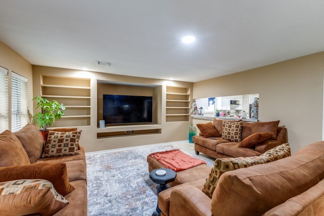 living room featuring built in features and plenty of natural light