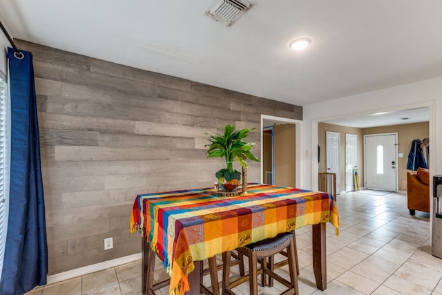 tiled dining area featuring wooden walls