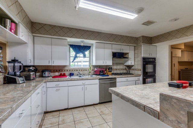 kitchen featuring appliances with stainless steel finishes, backsplash, and white cabinetry