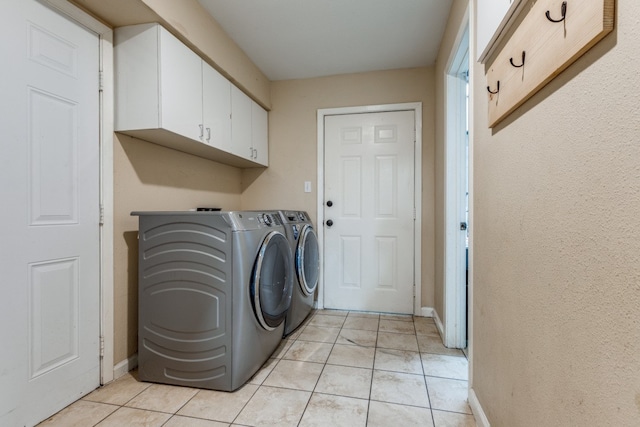 washroom with separate washer and dryer, cabinets, and light tile floors