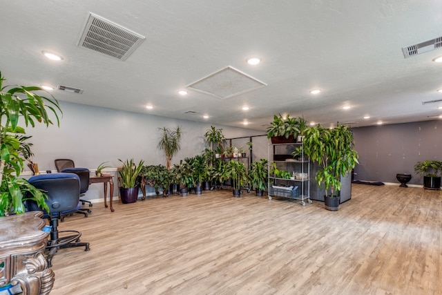 interior space with a textured ceiling and light hardwood / wood-style floors