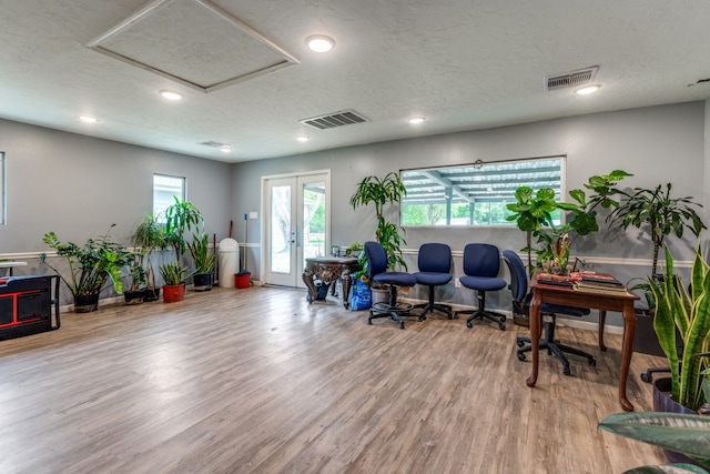 office area with french doors, a textured ceiling, and light hardwood / wood-style flooring