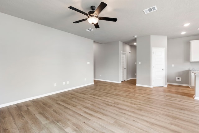 unfurnished living room with light hardwood / wood-style floors, a textured ceiling, and ceiling fan