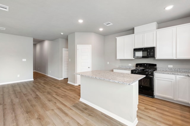 kitchen with black appliances, white cabinetry, light wood-type flooring, and a kitchen island