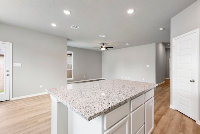 kitchen with plenty of natural light, ceiling fan, and light wood-type flooring