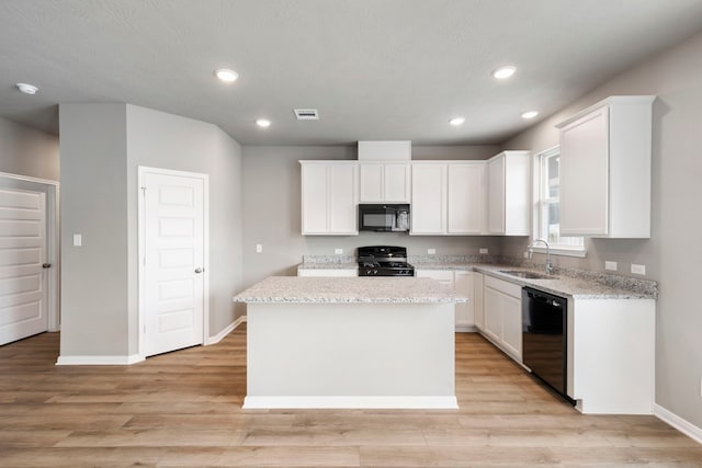 kitchen featuring black appliances, sink, a kitchen island, light hardwood / wood-style floors, and white cabinets