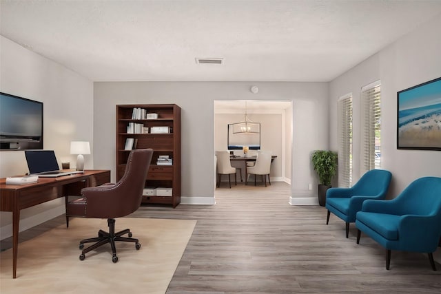 office space with an inviting chandelier and hardwood / wood-style flooring