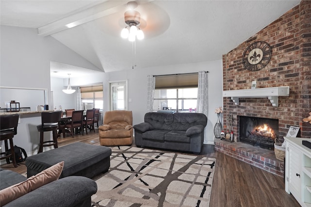 living room with ceiling fan, vaulted ceiling with beams, dark wood-type flooring, and a brick fireplace