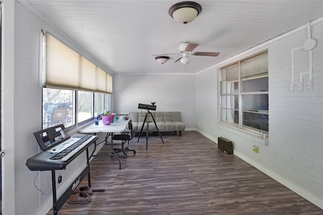 interior space with brick wall, dark hardwood / wood-style floors, and ceiling fan