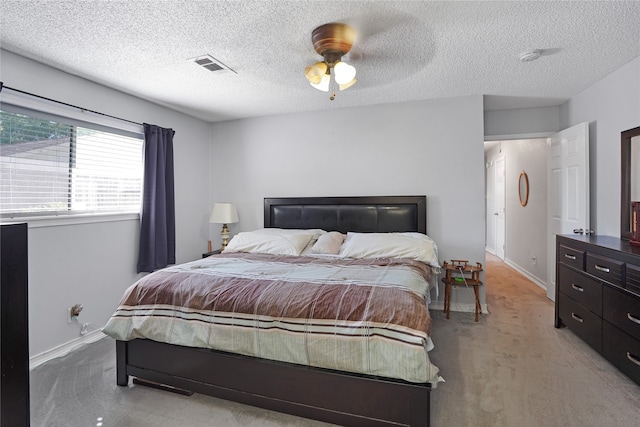 bedroom with ceiling fan, a textured ceiling, and light carpet