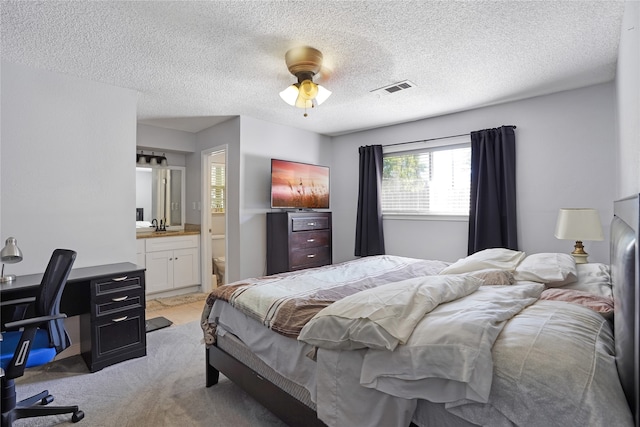 carpeted bedroom with connected bathroom, ceiling fan, a textured ceiling, and sink