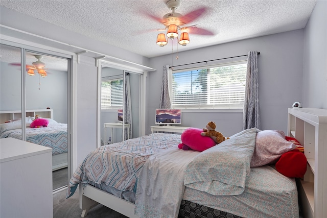 carpeted bedroom with ceiling fan, a textured ceiling, and multiple windows