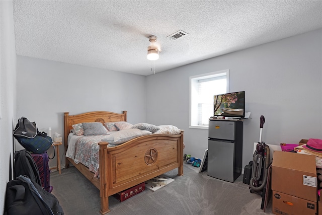 carpeted bedroom featuring ceiling fan and a textured ceiling