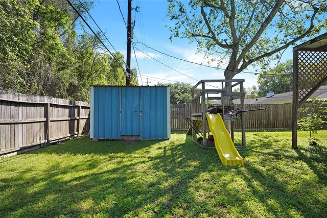 view of yard featuring a storage unit and a playground