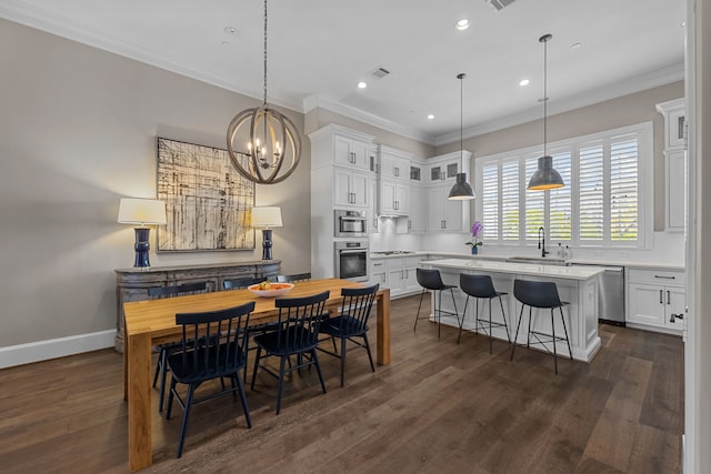 dining room with sink, dark hardwood / wood-style floors, ornamental molding, and a notable chandelier