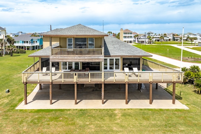 rear view of property featuring a yard, a patio area, and a balcony